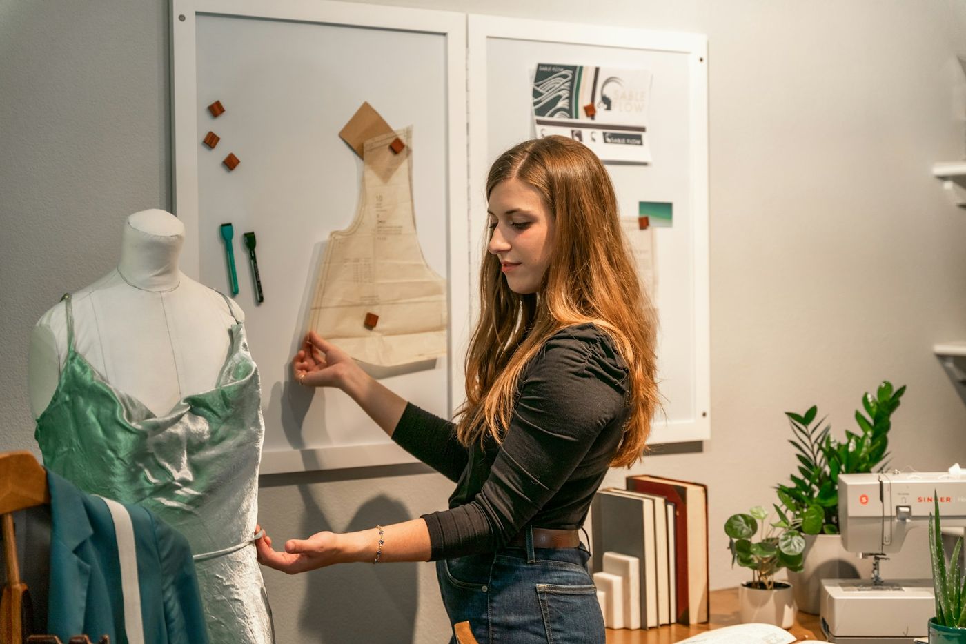 Designer fitting a dress on a mannequin in a sewing studio